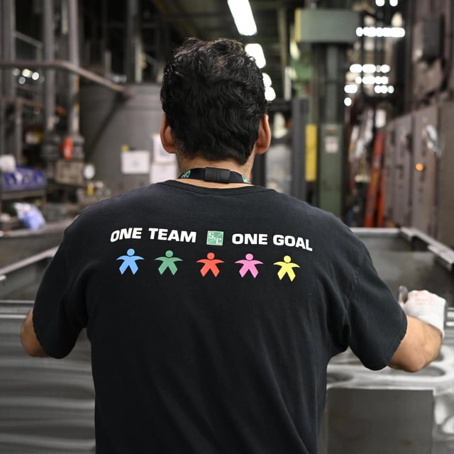 A team member displays S&C's "one team, one goal" slogan A team member displays S&C's "one team, one goal" slogan