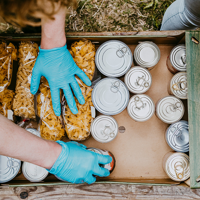 Hands organizing non-perishable food donations for distribution. community, philanthropy, donation, charity